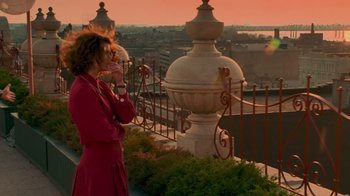 Movie still from “The Firm” (1993), directed by Sydney Pollack – A woman standing on top of a building near a fence; Wide shot, Low angle