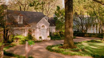 Movie still from “The Firm” (1993), directed by Sydney Pollack – A white house sitting next to a tree and some bushes; Extreme Wide shot, High angle