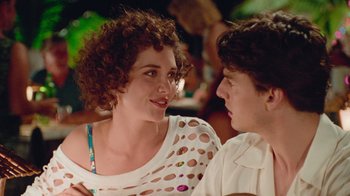 Movie still from “The Firm” (1993), directed by Sydney Pollack – A woman and a man sitting next to each other at an event; Close Up shot, Over the shoulder angle