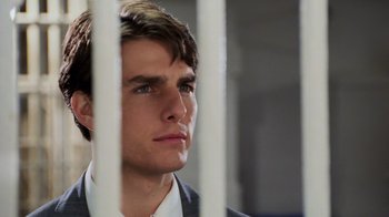 Movie still from “The Firm” (1993), directed by Sydney Pollack – A man in a suit looking through a fence; Close Up shot, Over the shoulder angle