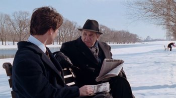 Movie still from “The Firm” (1993), directed by Sydney Pollack – A man in a hat and a man in a suit and tie; Medium shot, Over the shoulder angle