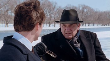 Movie still from “The Firm” (1993), directed by Sydney Pollack – An older man wearing a hat talking to a younger man; Close Up shot, Over the shoulder angle
