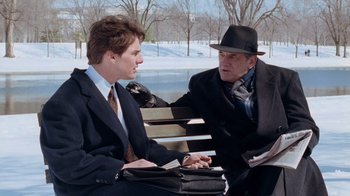 Movie still from “The Firm” (1993), directed by Sydney Pollack – Two men sitting on a park bench talking to each other; Medium shot, Over the shoulder angle