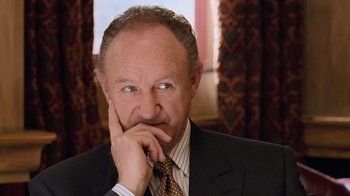 Movie still from “The Firm” (1993), directed by Sydney Pollack – An older man wearing a suit and tie with his hand under his chin; Close Up shot, Low angle