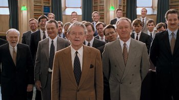 Movie still from “The Firm” (1993), directed by Sydney Pollack – A group of men in suits and ties standing in front of each other; Wide shot, Low angle