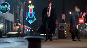 Movie still from “The Firm” (1993), directed by Sydney Pollack – A man standing on the side of the street at night; Wide shot, Low angle
