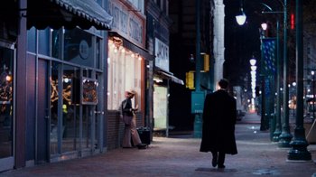 Movie still from “The Firm” (1993), directed by Sydney Pollack – A man walking down the street in front of a store; Wide shot, Over the shoulder angle