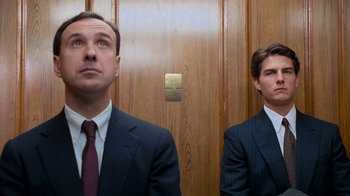 Movie still from “The Firm” (1993), directed by Sydney Pollack – Two men in suits standing in front of a door; Medium shot, Low angle