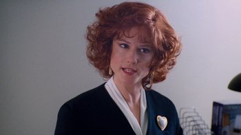 Movie still from “The Firm” (1993), directed by Sydney Pollack – A person with curly hair wearing a suit; Close Up shot, Over the shoulder angle