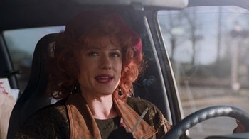 Movie still from “The Firm” (1993), directed by Sydney Pollack – A woman with red hair sitting in the driver's seat of a car; Close Up shot, Low angle