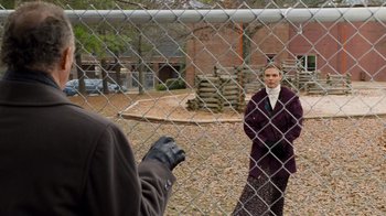 Movie still from “The Firm” (1993), directed by Sydney Pollack – A person standing in front of a chain link fence; Wide shot, Over the shoulder angle
