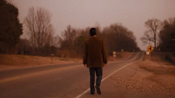 Movie still from “The Firm” (1993), directed by Sydney Pollack – A man walking down the middle of a road; Wide shot, Low angle