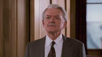 Movie still from “The Firm” (1993), directed by Sydney Pollack – An older man wearing a suit and tie; Close Up shot, Low angle