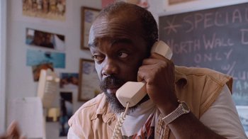Movie still from “The Firm” (1993), directed by Sydney Pollack – An older man talking on a phone in a room; Close Up shot, Low angle
