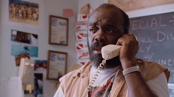 Movie still from “The Firm” (1993), directed by Sydney Pollack – An older man talking on a phone in a room; Close Up shot, Low angle