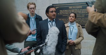 Movie still from “The Flash” (2023), directed by Andy Muschietti – A group of people standing next to each other on a sidewalk; Medium shot, Over the shoulder angle