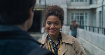 Movie still from “The Flash” (2023), directed by Andy Muschietti – A young woman smiles at the camera as she talks to a man; Close Up shot, Over the shoulder angle
