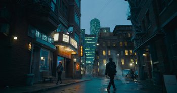 Movie still from “The Flash” (2023), directed by Andy Muschietti – A man walking down a street in the rain; Extreme Wide shot, Low angle