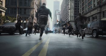 Movie still from “The Flash” (2023), directed by Andy Muschietti – A group of people running down a street; Wide shot, High angle