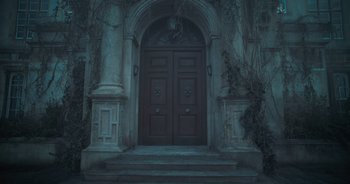 Movie still from “The Flash” (2023), directed by Andy Muschietti – A large wooden door on a building with steps leading up to it; Wide shot, Low angle