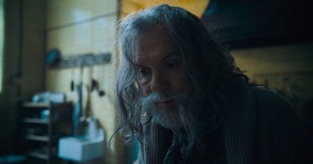 Movie still from “The Flash” (2023), directed by Andy Muschietti – An older man with long grey hair and a beard; Close Up shot, Over the shoulder angle