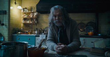 Movie still from “The Flash” (2023), directed by Andy Muschietti – An older man sitting at a kitchen counter; Medium shot, Low angle