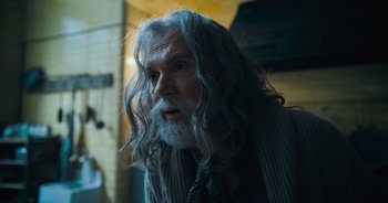 Movie still from “The Flash” (2023), directed by Andy Muschietti – An old man with long grey hair and a beard; Close Up shot, Over the shoulder angle