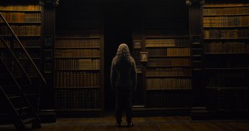 Movie still from “The Flash” (2023), directed by Andy Muschietti – A woman standing in front of a book shelf; Wide shot, Low angle