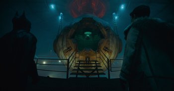 Movie still from “The Flash” (2023), directed by Andy Muschietti – A man standing in front of stairs in a room; Extreme Wide shot, High angle