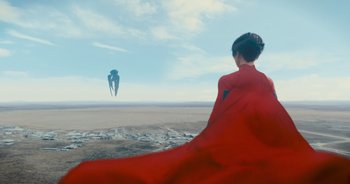 Movie still from “The Flash” (2023), directed by Andy Muschietti – A woman in a red cape looking out at a kite; Extreme Wide shot, Low angle