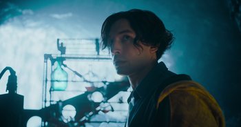 Movie still from “The Flash” (2023), directed by Andy Muschietti – A man with long dark hair standing in front of a building; Close Up shot, Low angle