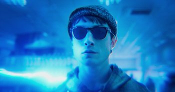 Movie still from “The Flash” (2023), directed by Andy Muschietti – A young man wearing sunglasses and a hat; Close Up shot, Low angle
