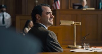 Movie still from “The Flash” (2023), directed by Andy Muschietti – A man sitting in front of a judge in a courtroom; Medium shot, Over the shoulder angle
