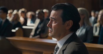 Movie still from “The Flash” (2023), directed by Andy Muschietti – A person wearing a suit and tie; Close Up shot, Over the shoulder angle