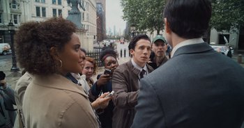 Movie still from “The Flash” (2023), directed by Andy Muschietti – A group of people standing on a street corner; Medium shot, Over the shoulder angle