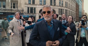 Movie still from “The Flash” (2023), directed by Andy Muschietti – A man in a suit and sunglasses; Medium shot, Low angle