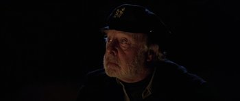 Movie still from “The Fog” (1980), directed by John Carpenter – An older man wearing a black hat and a black jacket; Close Up shot, Over the shoulder angle