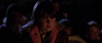 Movie still from “The Fog” (1980), directed by John Carpenter – A young boy wearing a red jacket and a brown jacket; Close Up shot, Over the shoulder angle