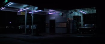 Movie still from “The Fog” (1980), directed by John Carpenter – A starbucks sign is lit up at night time; Extreme Wide shot, Low angle
