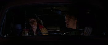 Movie still from “The Fog” (1980), directed by John Carpenter – A man and a woman sitting in the back seat of a car; Medium shot, High angle