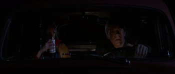 Movie still from “The Fog” (1980), directed by John Carpenter – A man and a child in a car at night; Medium shot, Over the shoulder angle