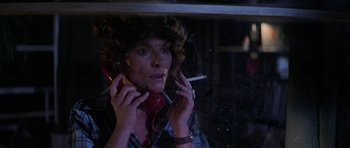 Movie still from “The Fog” (1980), directed by John Carpenter – A woman holding a cigarette and a cell phone in her hands; Close Up shot, Low angle