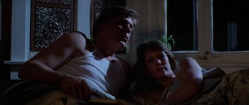 Movie still from “The Fog” (1980), directed by John Carpenter – A man and a woman sitting next to each other on a couch; Medium shot, Low angle