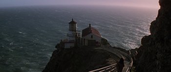 Movie still from “The Fog” (1980), directed by John Carpenter – A lighthouse on top of an island near the ocean; Extreme Wide shot, Low angle