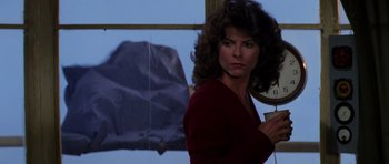 Movie still from “The Fog” (1980), directed by John Carpenter – A woman holding an umbrella in front of a window; Medium shot, Low angle