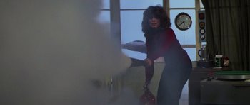 Movie still from “The Fog” (1980), directed by John Carpenter – A woman in a red shirt is holding a red bag; Medium shot, Low angle