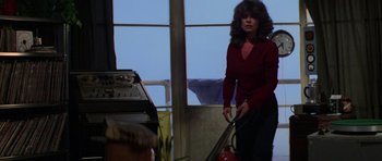 Movie still from “The Fog” (1980), directed by John Carpenter – A woman in a red shirt is holding a fire extinguisher; Medium shot, Low angle