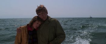 Movie still from “The Fog” (1980), directed by John Carpenter – A man and a woman standing next to each other on a beach; Medium shot, Low angle