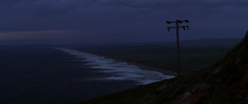 Movie still from “The Fog” (1980), directed by John Carpenter – A view of the ocean at night from a hill; Extreme Wide shot, Low angle