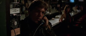 Movie still from “The Fog” (1980), directed by John Carpenter – A man talking on a phone while sitting at a bar; Close Up shot, Low angle